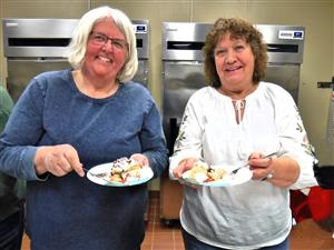 two women enjoying dessert dish