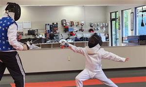 kid fencing with teacher