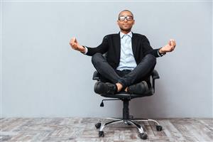 man meditating on office chair