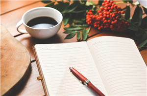 open blank journal with coffee