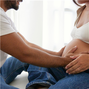father holding pregnant mother's stomach