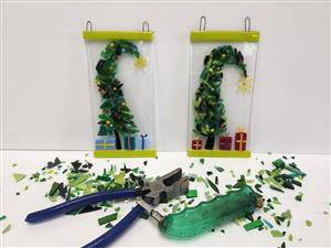 fused glass Xmas trees with cutting tools and glass pieces surrounding the trees