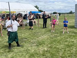 long sword demonstration at renaissance fair with adults and kids