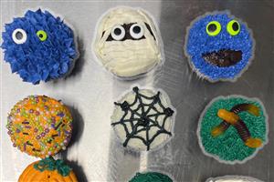 Halloween inspired cupcakes with mummies, candy worms, spiderwebs and pumpkin designs