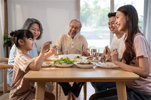 Family sitting down for dinner talking