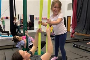 Mom and daughter smiling while using aerial silks