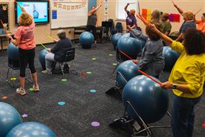 Class practicing ball drumming