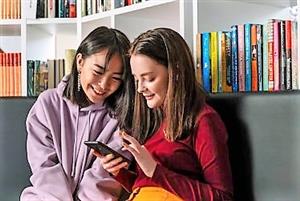 Two teen girls looking at a cell phone