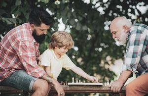 grandfather, father, and son playing chess