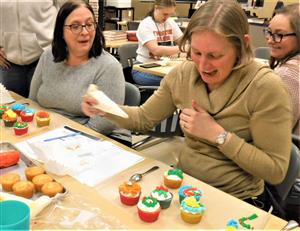 women decorating cupcakes with frosting